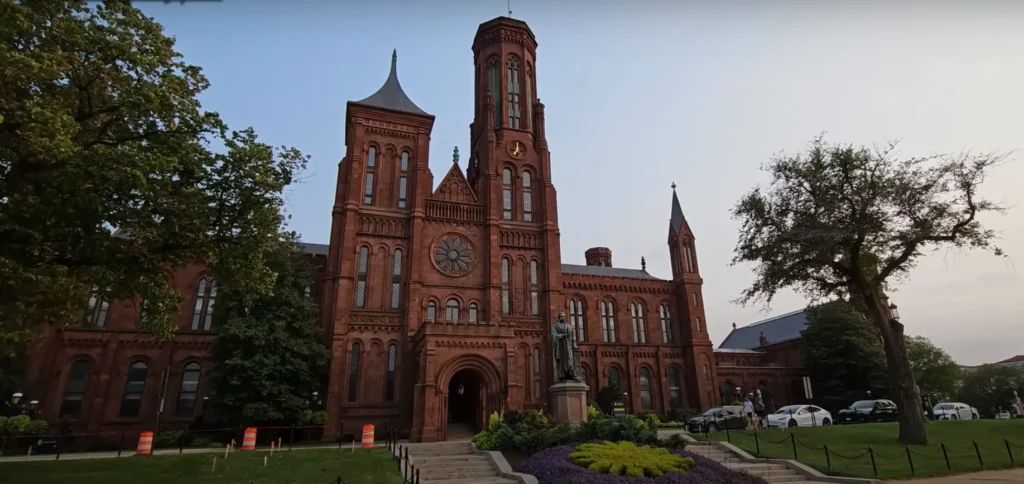 The Smithsonian Institution Building, also known as the Smithsonian Castle, with its distinctive red stone architecture and surrounding greenery in Washington, DC.
